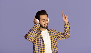 Milenyum Hint müzik aşığı menekşe arka planda en sevdiği şarkıları kulaklıkla dinliyor.