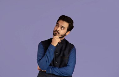 Kafası karışmış Hintli bir adam yana bakıyor ve bir şeyler düşünüyor, leylak arkaplan