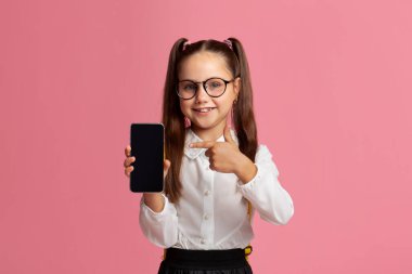 Uzaktan eğitim. Gözlüklü küçük öğrenci akıllı telefondan ekranı boş gösteriyor.