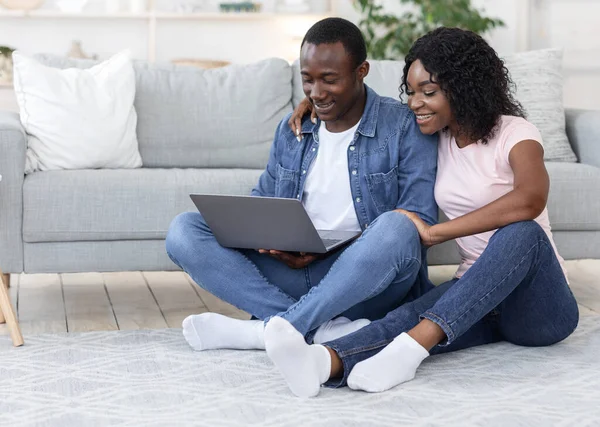 Afroamerikanische Liebhaber sitzen zu Hause mit Laptop auf dem Fußboden — Stockfoto