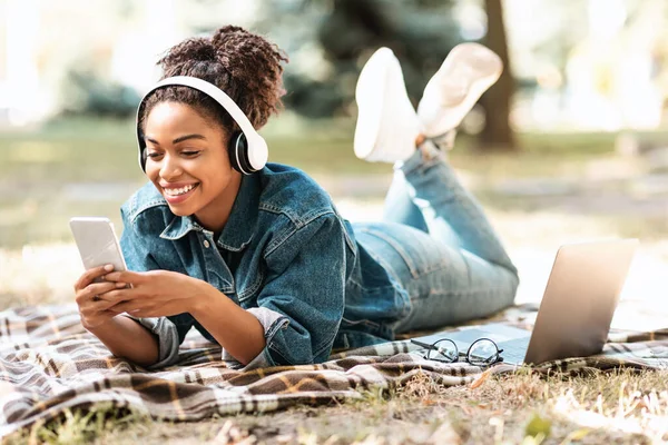 Neşeli Siyah Kız Telefonunu Kullanıyor Ekose üzerinde yalan söylemeyi öğreniyor