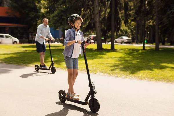 Feliz chico con papá teniendo paseo en scooter de patada eléctrica — Foto de Stock