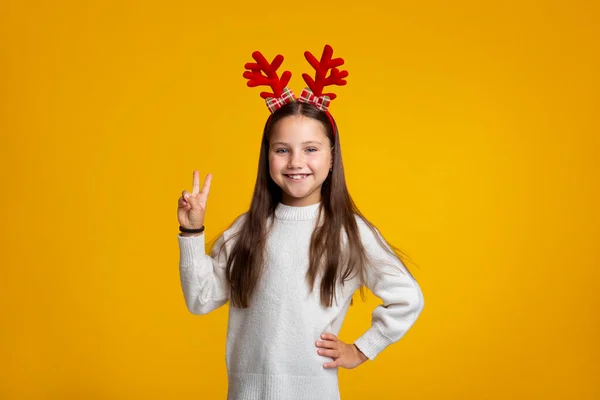 Wachten op vakantie. Gelukkig kind met hoorns toont vrede teken met vingers — Stockfoto