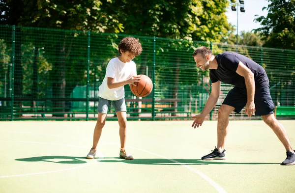 Ώριμος προπονητής διδάσκει αγόρι πώς να παίξει μπάσκετ — Φωτογραφία Αρχείου