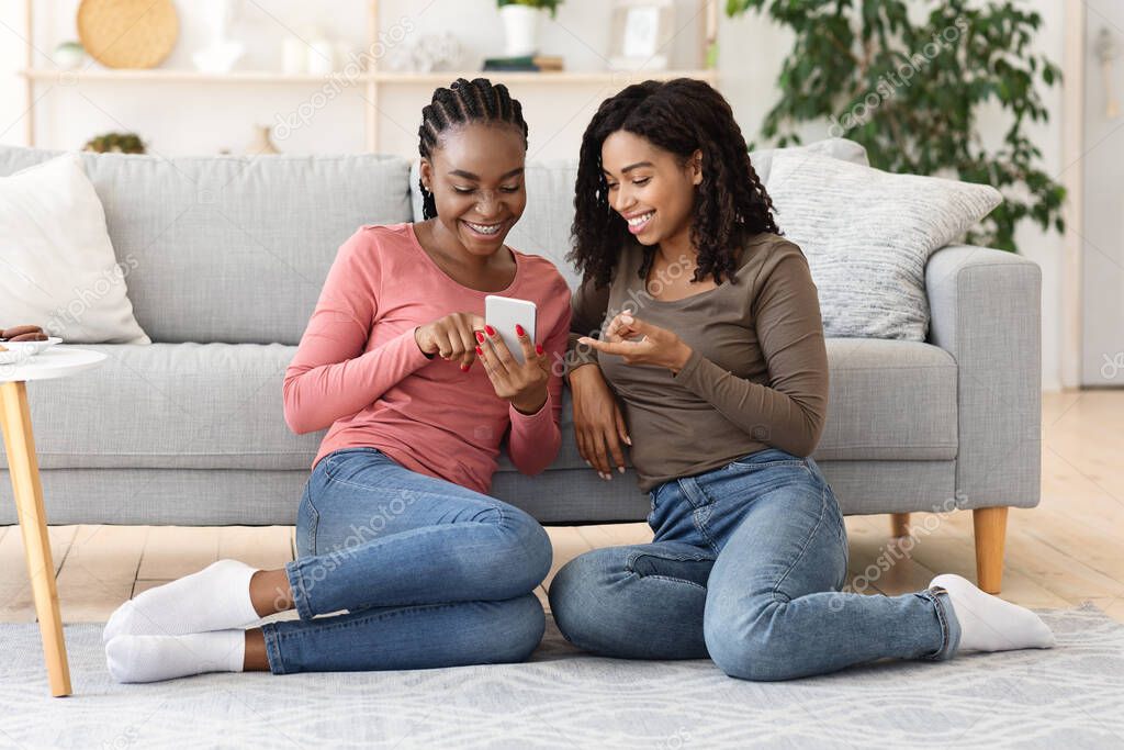 Happy black girls using new mobile app