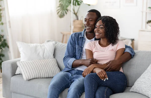 Happy black lovers watching movie together at home