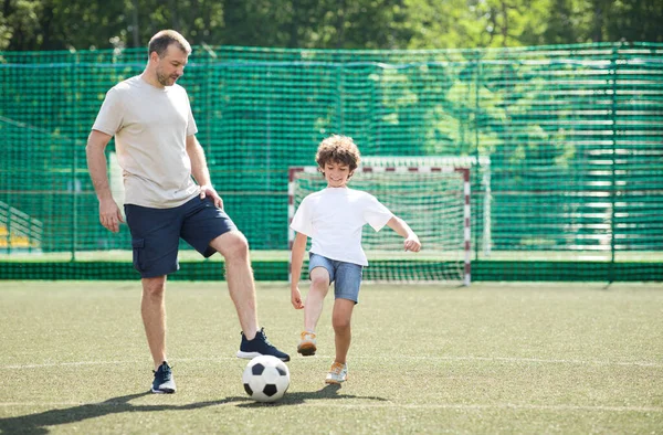 Sportive dad teaching his son how to play football — Stock Photo, Image
