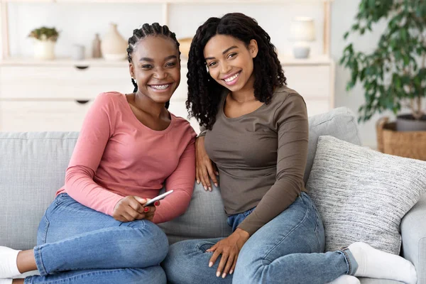 快乐的非洲女人坐在家里的沙发上 — 图库照片