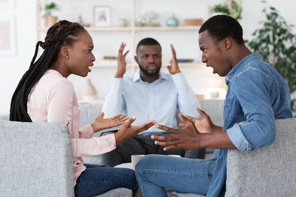 Huwelijkstherapie. Geschokt Family Counselor over het hoofd zwarte paar ruziën op zijn kantoor — Stockfoto