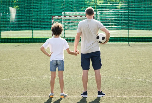 Dad posing with little boy on football pitch, back view — Stock Photo, Image
