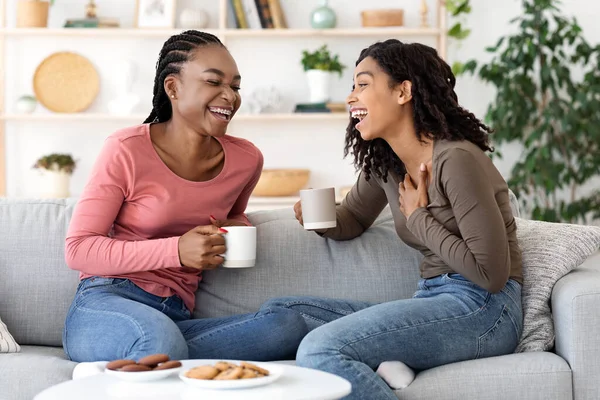 Two african besties laughing while drinking tea together at home — Stock Photo, Image