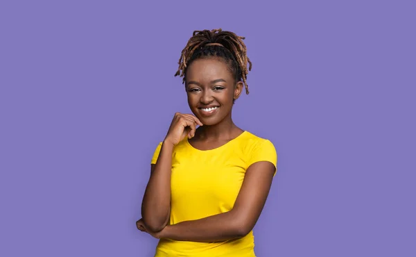 Довольно улыбающаяся африканская американская молодая женщина на фиолетовом фоне — стоковое фото