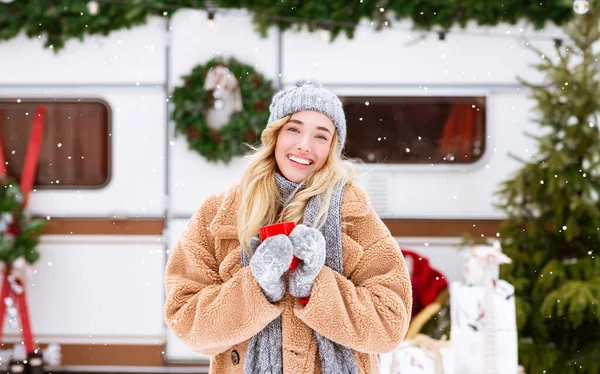 Cuento de hadas de invierno. Mujer sonriente bebiendo té al aire libre y mirando nevadas —  Fotos de Stock