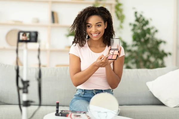 Africano beleza blogueiro menina fazendo vídeo revisão cosméticos em casa — Fotografia de Stock