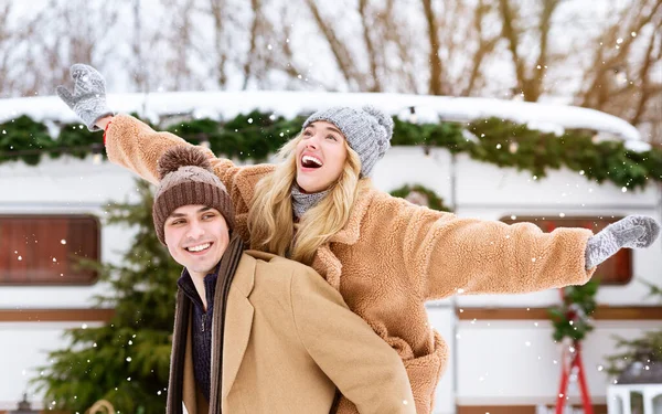 Glückliches Winterpaar hat Spaß im Freien auf dem Campingplatz, Kerl huckepack seine Freundin — Stockfoto