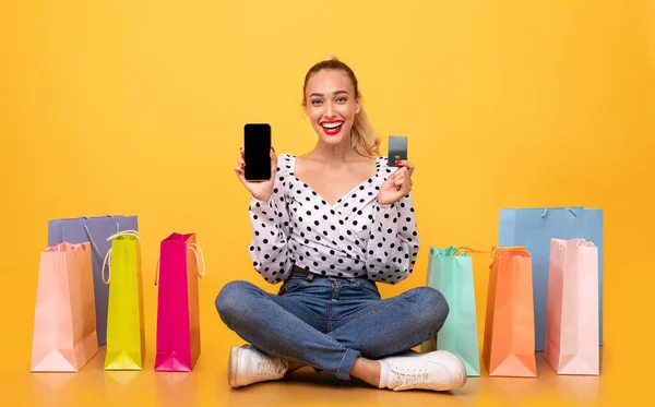 Lycklig kvinna med shoppingväskor, telefon och plastkort — Stockfoto