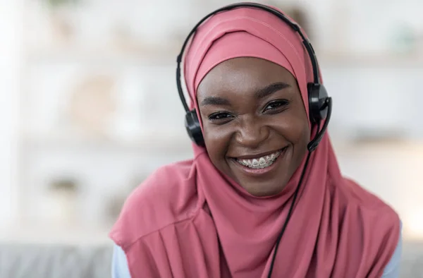 Portrait of african muslim woman in hijab and headset at home — Stok Foto
