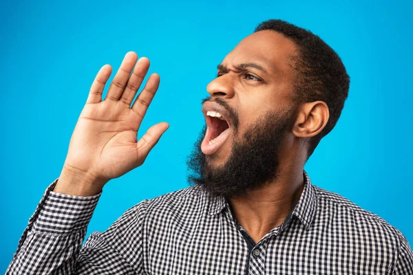 Negro chico celebración palma cerca boca, gritando a un lado en copyspace — Foto de Stock