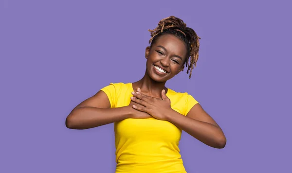 Wdzięczna uśmiechnięta afrykańska dziewczyna trzymająca się za ręce na piersi — Zdjęcie stockowe