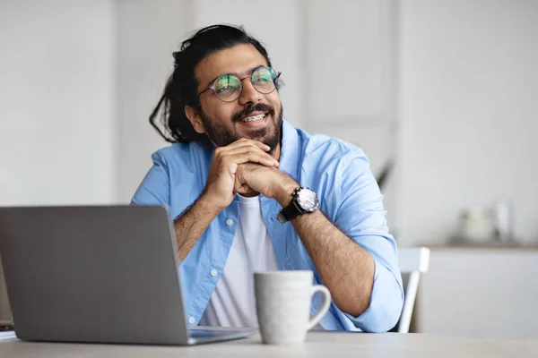 Pensive freelancer denken over iets tijdens het werken aan laptop op kantoor — Stockfoto
