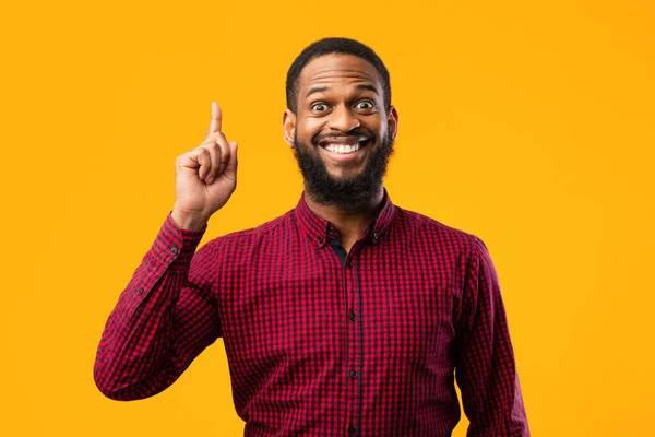 Emocionado hombre negro teniendo una gran idea y apuntando hacia arriba — Foto de Stock