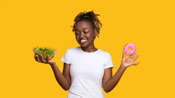 Mosolygó afrikai nő nézi friss saláta — Stock Fotó