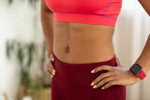 Menina preta irreconhecível mostrando barriga muscular plana ao ar livre, close-up, cortada — Fotografia de Stock
