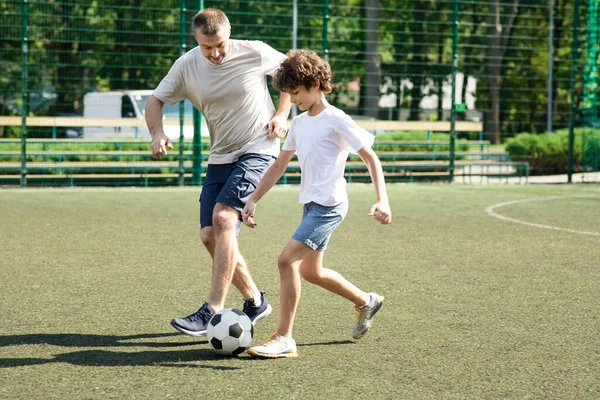 Sportive dad playing soccer with his little son — Stock Photo, Image