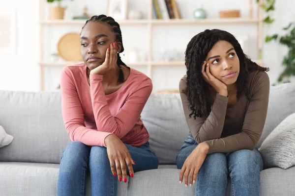 Två upprörda afrikanska kvinnor satt på soffan, grälade. — Stockfoto