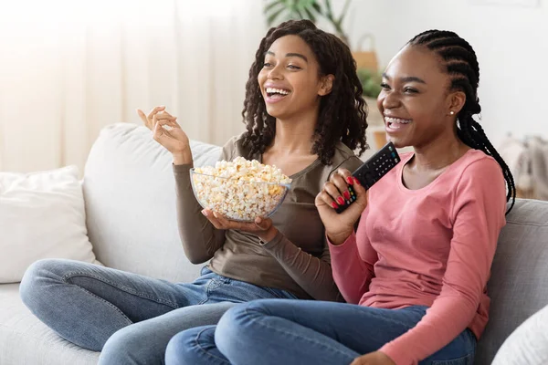 Felizes namoradas africanas comendo pipocas e assistindo filme — Fotografia de Stock