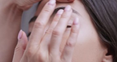 Profesyonel kozmetik uzmanı Asyalı genç bir kadın için kaş stili yapıyor.
