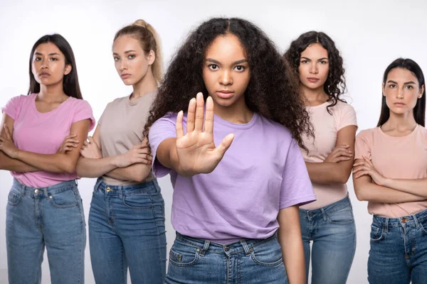 Nero donna gesturing smettere di proteggere gruppo di signore bianco sfondo — Foto Stock