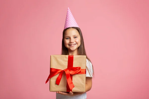 Doğum günü hediyesi. Şapkalı ve büyük hediyeli heyecanlı bir kız portresi. — Stok fotoğraf