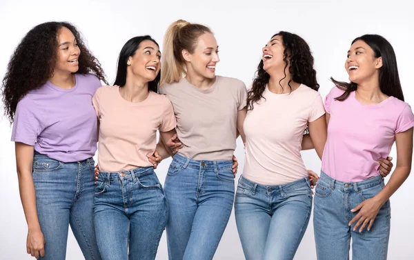 Felices mujeres multiétnicas abrazando riéndose de pie juntas sobre fondo blanco — Foto de Stock