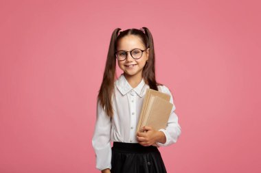 Okul ve eğitim. Üniformalı ve elinde kitaplarla gülümseyen bir öğrenci.