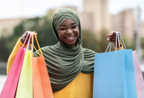 Alışveriş Konsepti. Neşeli Afrikalı Müslüman Kadın Parlak alışveriş torbalarıyla poz veriyor — Stok fotoğraf