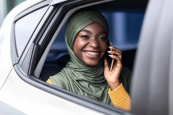 Zwarte moslim vrouw reizen op de achterbank van de auto en praten op mobiele telefoon — Stockfoto