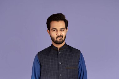 Yakışıklı Hintli adam menekşe arkaplanından şüphe ediyor.