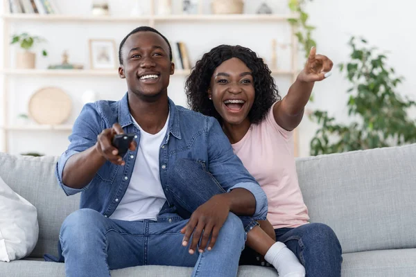 Emocional africano hombre y mujer viendo la televisión en casa —  Fotos de Stock