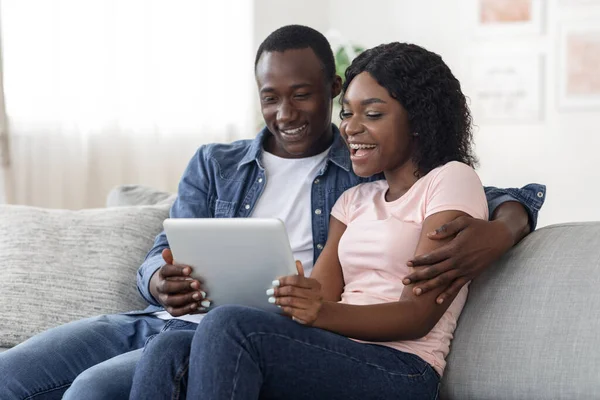 Sonriendo africano hombre y mujer websurf juntos en casa —  Fotos de Stock