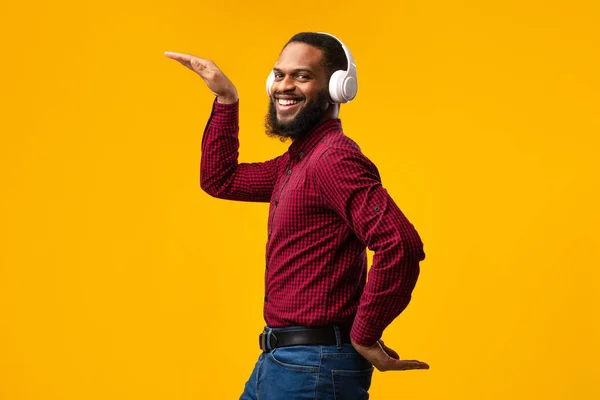 Lächelnder Schwarzer, der Musik mit Kopfhörern genießt und tanzt — Stockfoto