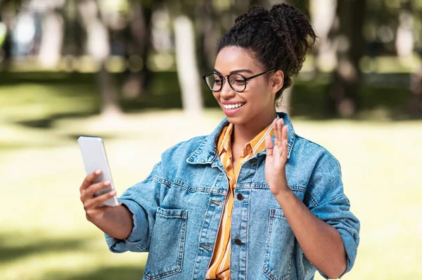 Czarna młoda kobieta za pomocą telefonu podejmowania rozmowy wideo Walking na zewnątrz — Zdjęcie stockowe