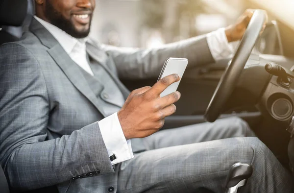 Nero ragazzo in vestito utilizzando smartphone durante la guida — Foto Stock