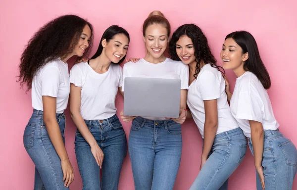 Group Of Multiracial Women Using Laptop Standing Over Pink Background