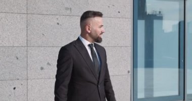 Kendine güvenen işadamı ofis binasını terk ediyor ve şehir manzarasının tadını çıkarıyor