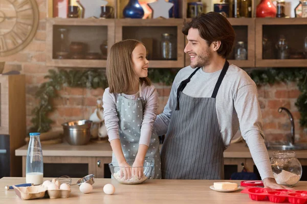 Mutlu baba ve küçük kız mutfakta turta pişiriyor, hamur yoğuruyorlar. — Stok fotoğraf