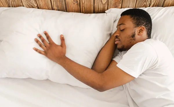 Africano homem dormindo depois de romper sozinho deitado na cama interior — Fotografia de Stock