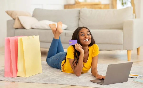 Bilgisayarı ve kredi kartı olan mutlu Afrikalı Amerikalı kadın evde online alışveriş yapıyor. — Stok fotoğraf