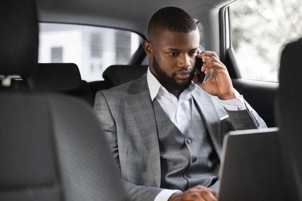 Konzentrierter schwarzer Geschäftsmann telefoniert im Auto — Stockfoto