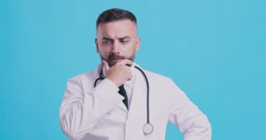 Düşünceli bir tıp doktorunun problem çözme üzerine düşünen stüdyo portresi.